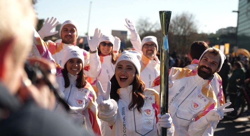 I tedofori posano davanti ai fotografi durante il passaggio della Torcia Olimpica a Milano