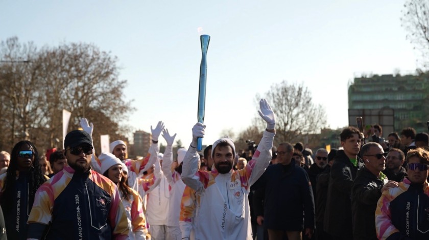 La Torcia Olimpica sfila per le strade di Milano sorretta da un tedoforo.  