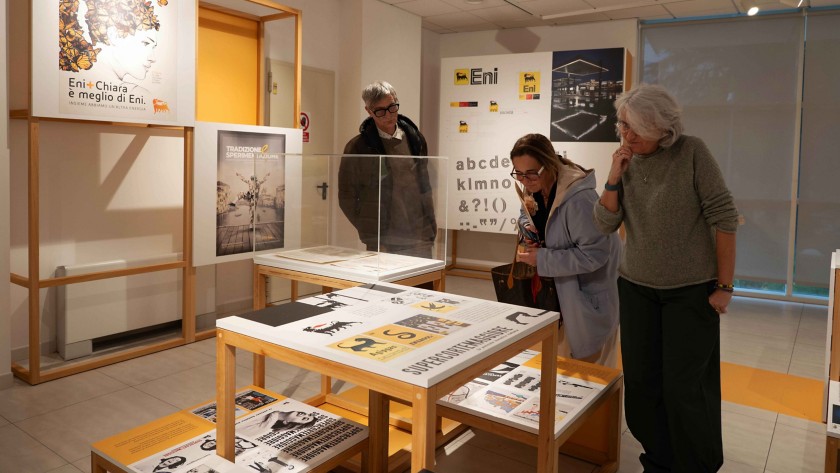 Visitatori che osservano le opere della  mostra sul brand Eni presso il Polo Bibliotecario di Potenza