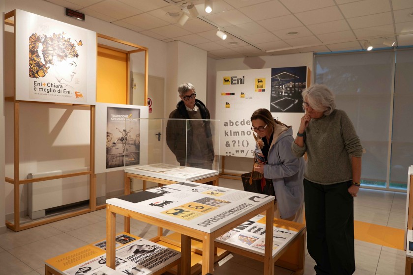 Visitatori che osservano le opere della  mostra sul brand Eni presso il Polo Bibliotecario di Potenza