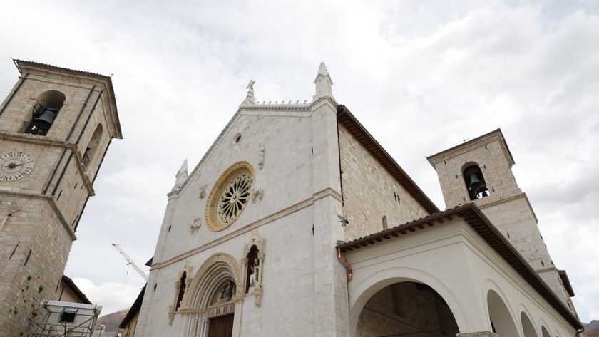 The facade of the Basilica of San Benedetto stands out towards the sky