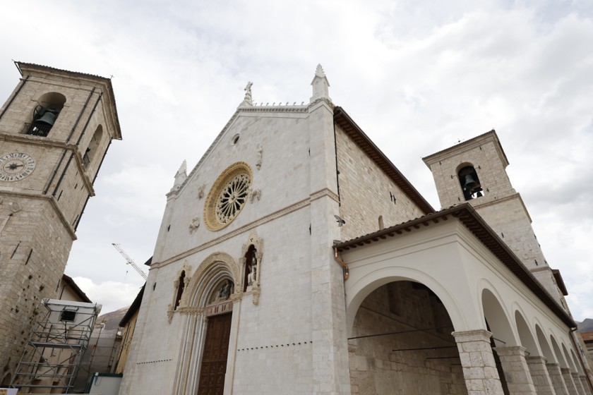 The facade of the Basilica of San Benedetto stands out towards the sky