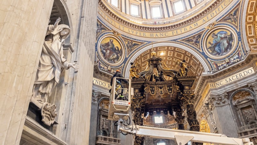 Un operatore su una piattaforma aerea lavora vicino alle colonne del Baldacchino di Bernini 