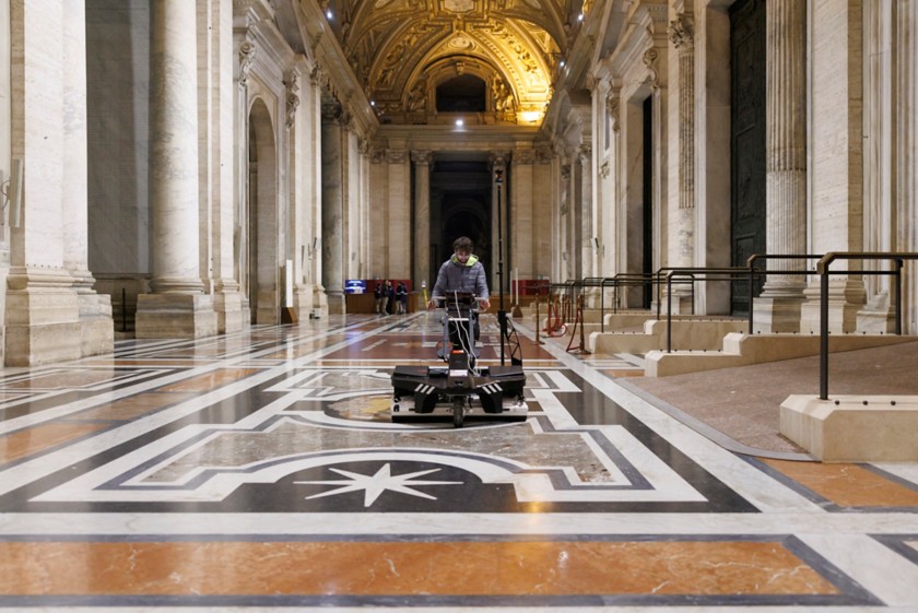Un tecnico manovra un veicolo robotico sul pavimento marmoreo della Basilica di San Pietro 