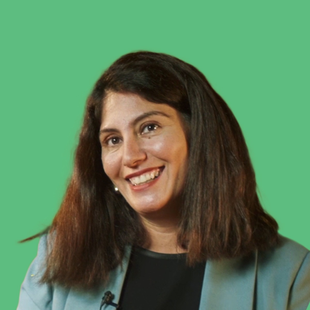 A smiling girl with black hair and a green dress