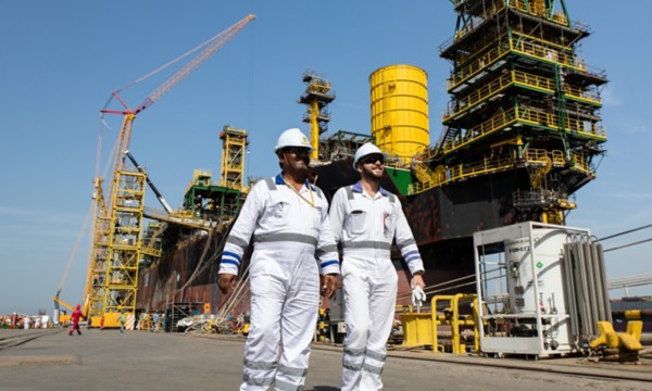 Operai camminano in porto davanti alla nave