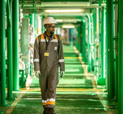 tecnico africano cammina in corridoio sotto raffineria