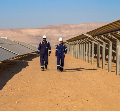 Due operai camminano nell'impianto fotovoltaico algerino
