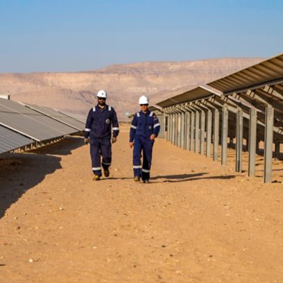 Due operai camminano nell'impianto fotovoltaico algerino
