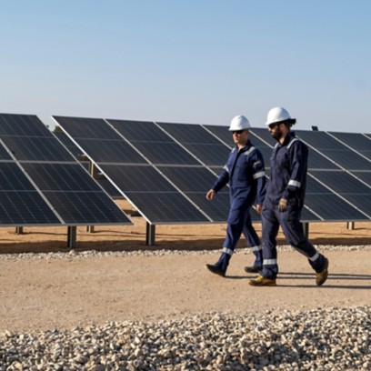 Due operai attraversano l'impianto fotovoltaico