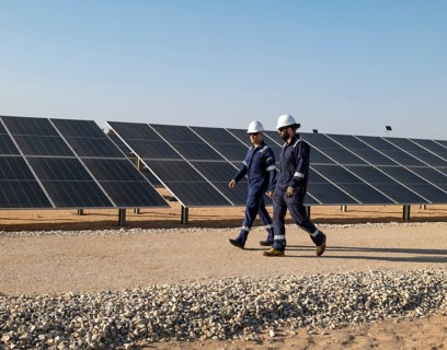 Due operai attraversano l'impianto fotovoltaico