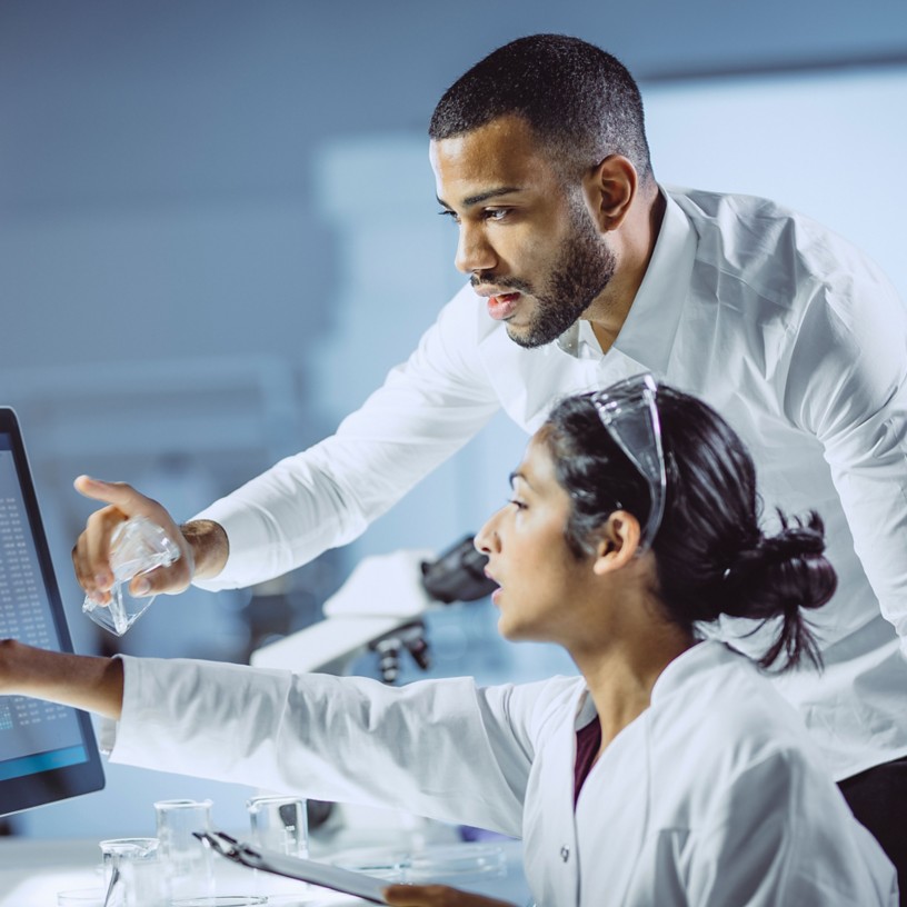 Due scienziati uomo e donna all'interno del laboratorio guardano lo schermo dei computer