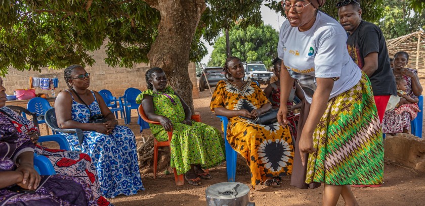 Women sitting around the improved stoves