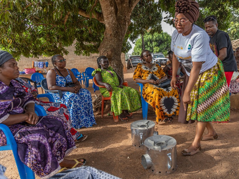 Women sitting around the improved stoves