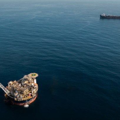 Veduta aerea di una piattaforma petrolifera offshore circondata dal mare con una nave cisterna in navigazione