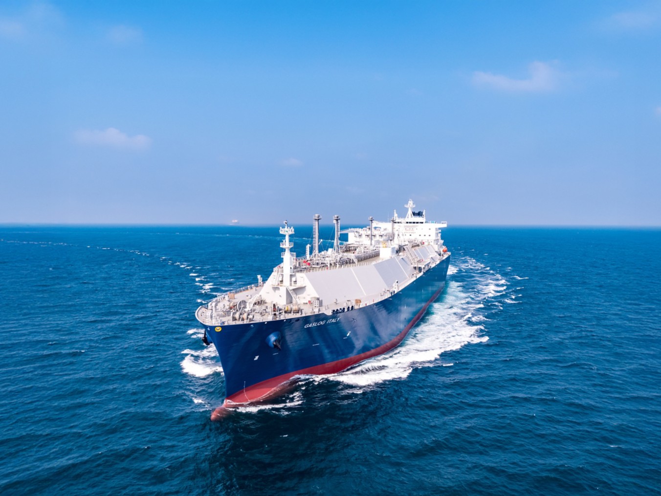 Una grande nave cargo per il trasporto di gas naturale liquefatto (GNL) naviga in mare aperto sotto un cielo limpido.