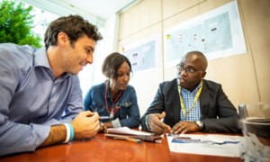 Gruppo di persone di diverse etnie sedute intorno a un tavolo in ufficio