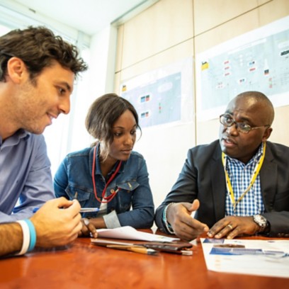 Group of people of different ethnicities sitting around a table in the office