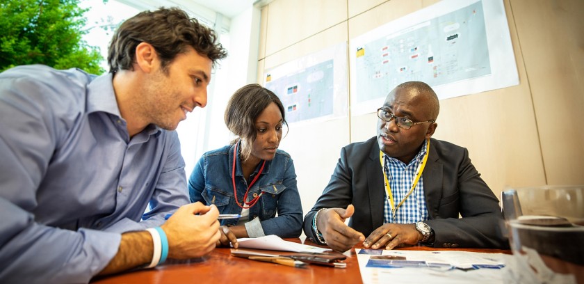 Gruppo di persone di diverse etnie sedute intorno a un tavolo in ufficio