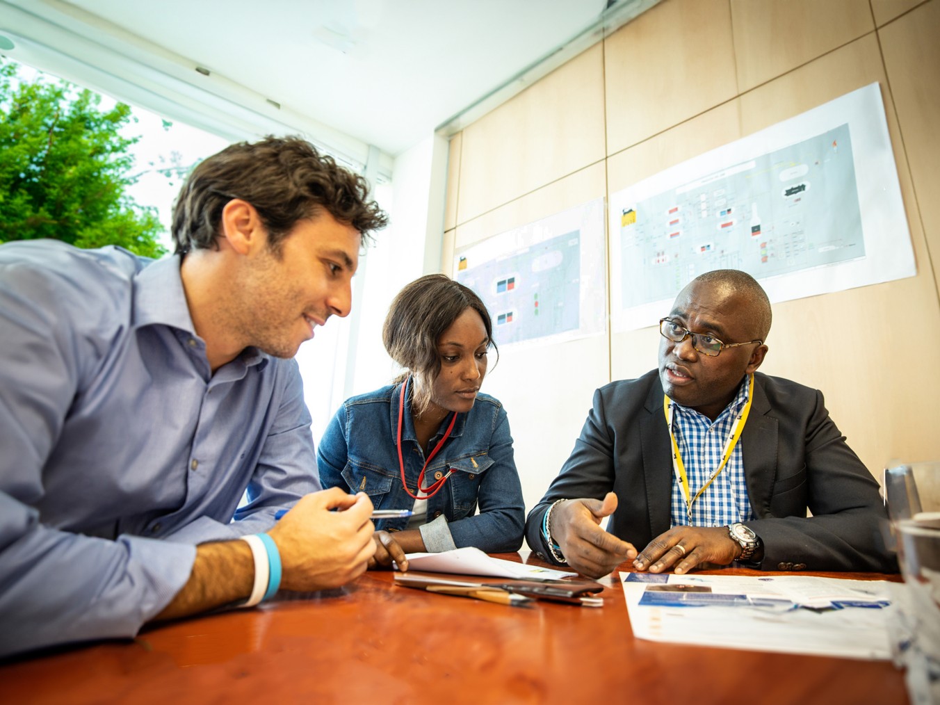Gruppo di persone di diverse etnie sedute intorno a un tavolo in ufficio