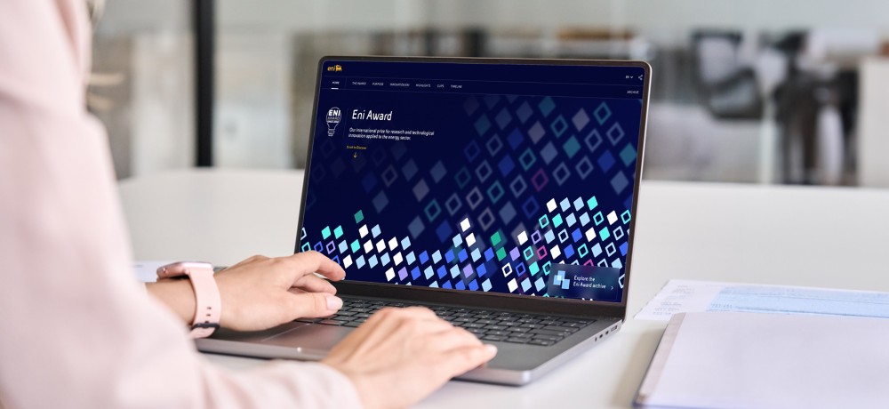 Una persona seduta in ufficio mentre guarda il longform Eni Award dal laptop