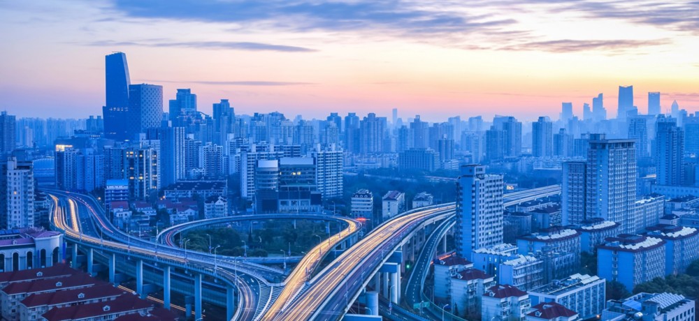 Veduta urbana con autostrade sopraelevate che si intrecciano tra grattacieli moderni, simbolo di mobilità e sviluppo urbano sostenibile.