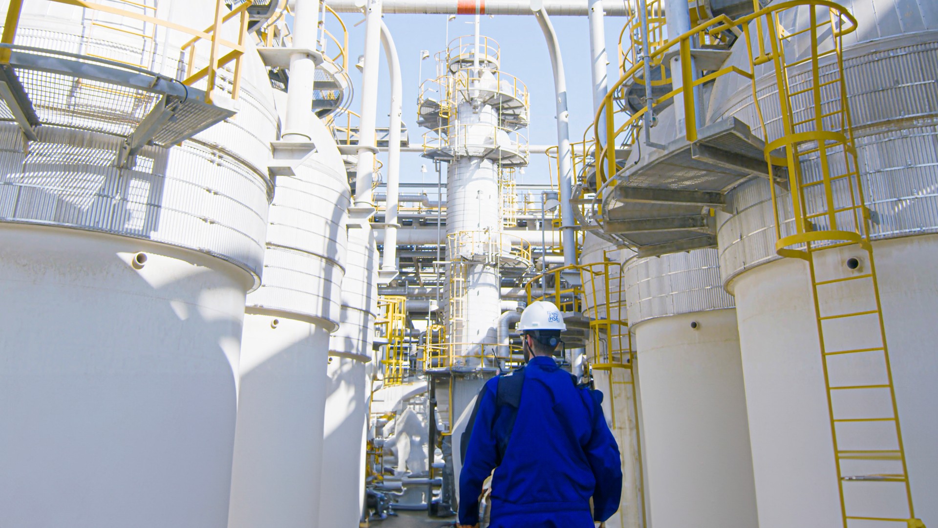 Worker walks with his back towards the plant