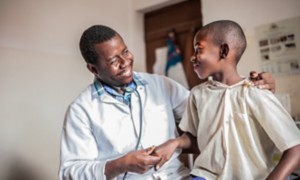 African male doctor examining child