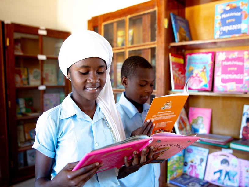 Una studentessa e uno studente mozambicani leggono in biblioteca