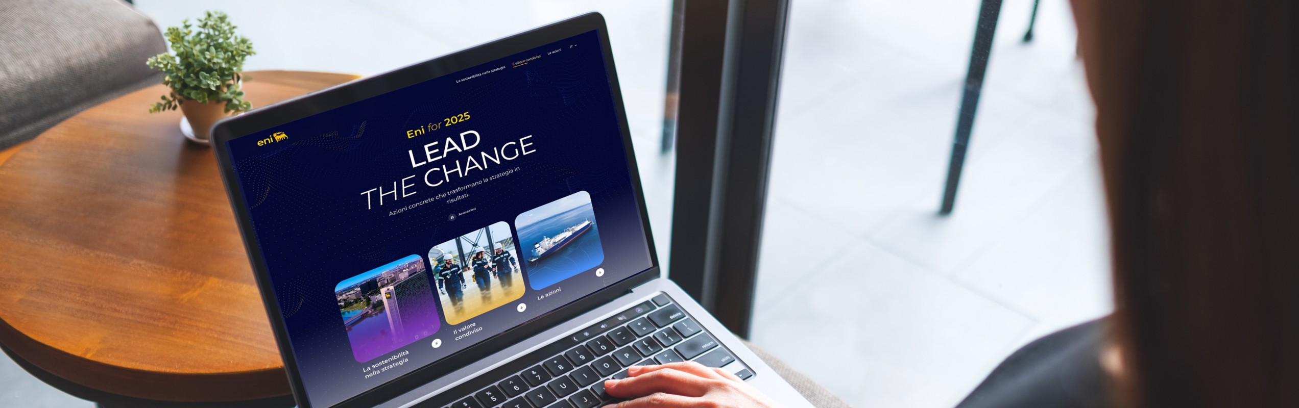 Donna seduta che lavora al computer portatile con il sito ‘Eni for 2025 – Lead the Change’ aperto sullo schermo