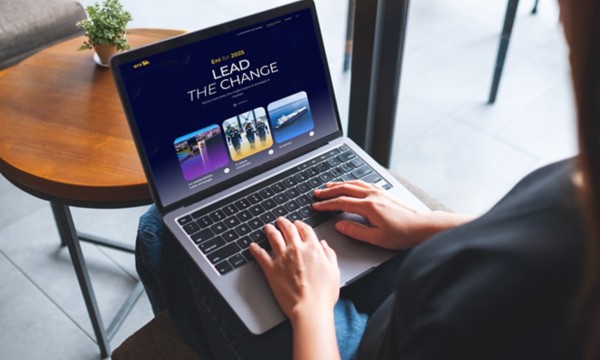 Donna seduta che lavora al computer portatile con il sito ‘Eni for 2025 – Lead the Change’ aperto sullo schermo