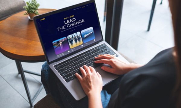 Woman sitting and working on a laptop with the ‘Eni for 2025 – Lead the Change’ website open on the screen