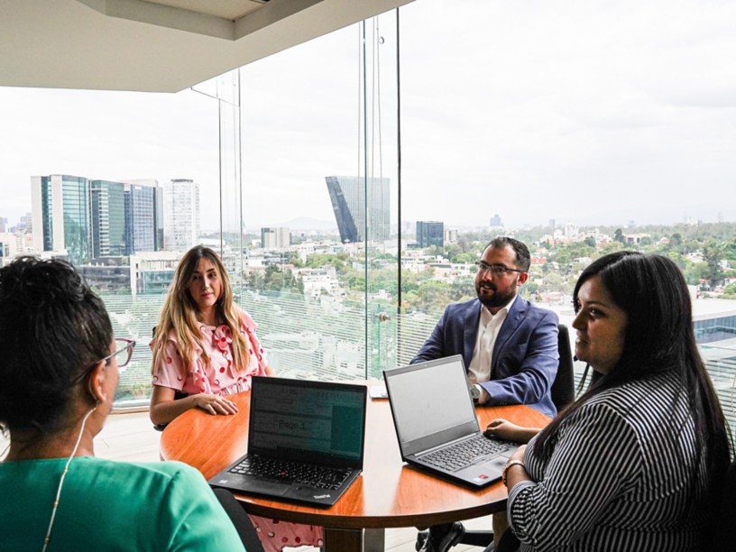 Several people sitting around a table in the office