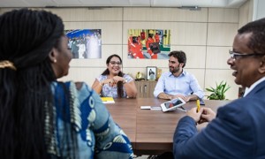 Group of people of different ethnicities sitting around a table in the office