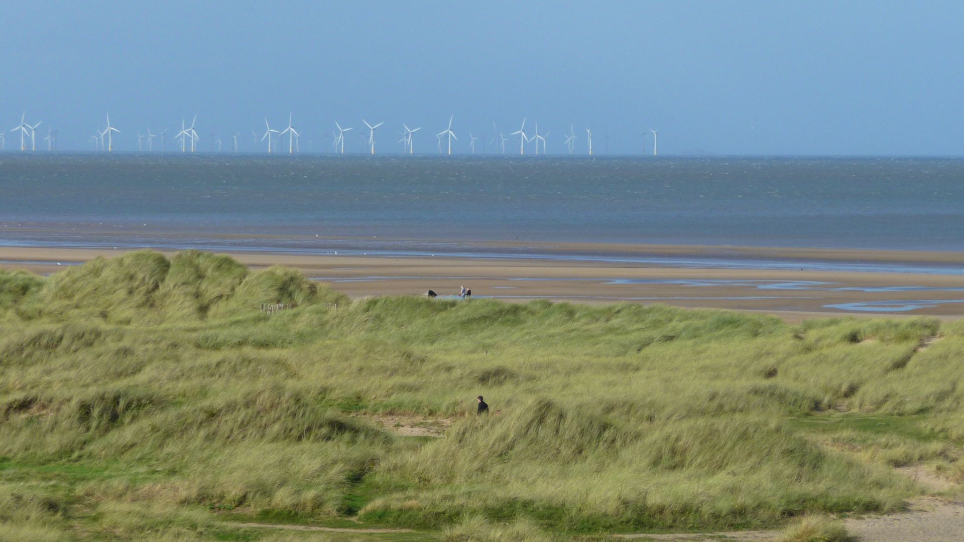 Paesaggio di spiaggia inglese con pale eoliche