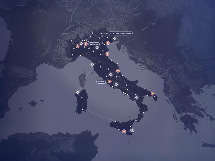 Mappa stilizzata dell’Italia e delle regioni circostanti, con città principali evidenziate e linee luminose che collegano i nodi, suggerendo una rete di trasporti, comunicazioni o dati in un contesto digitale.