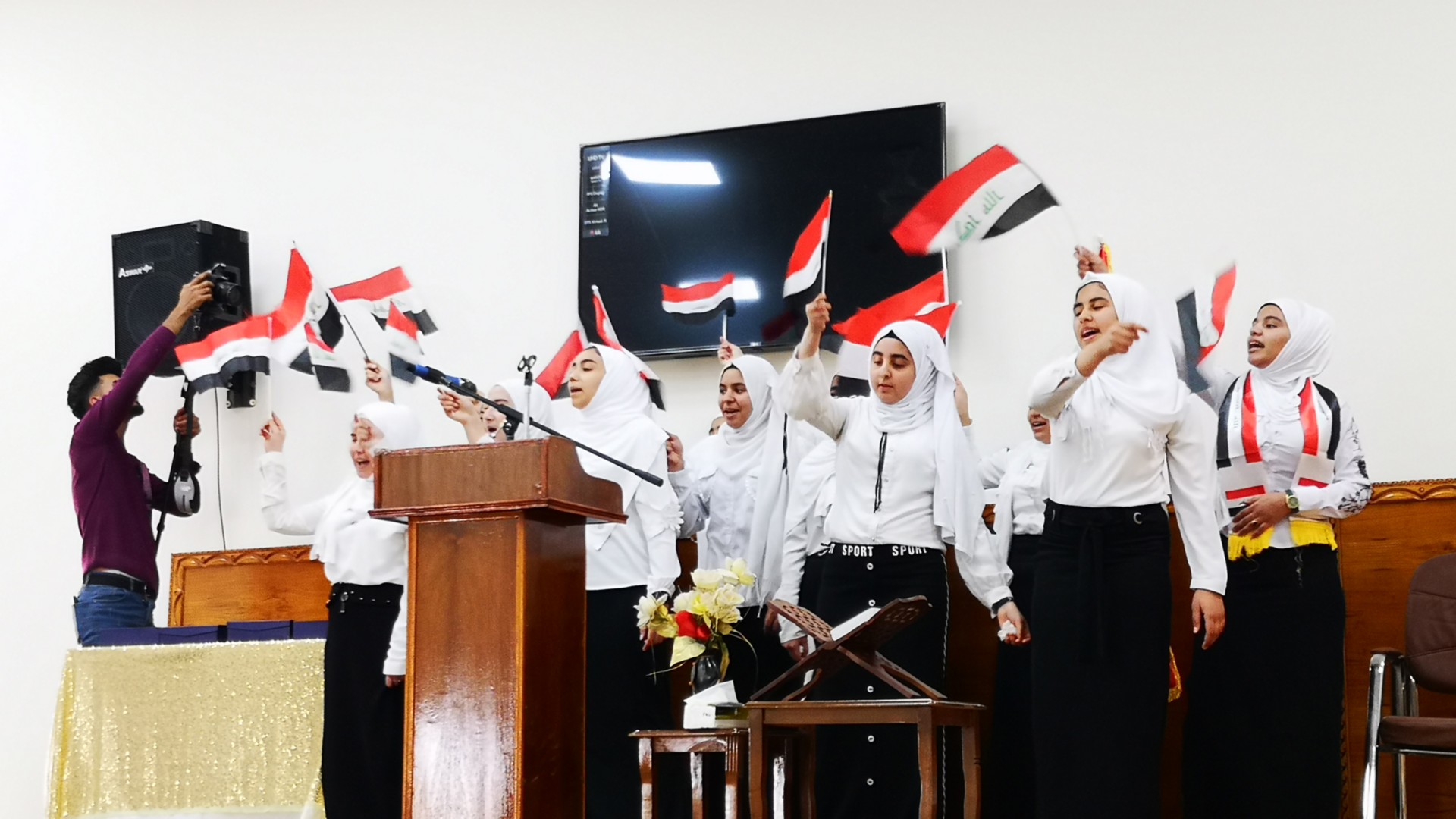 Gruppo di bambini iraniani sventolano la bandiera del paese