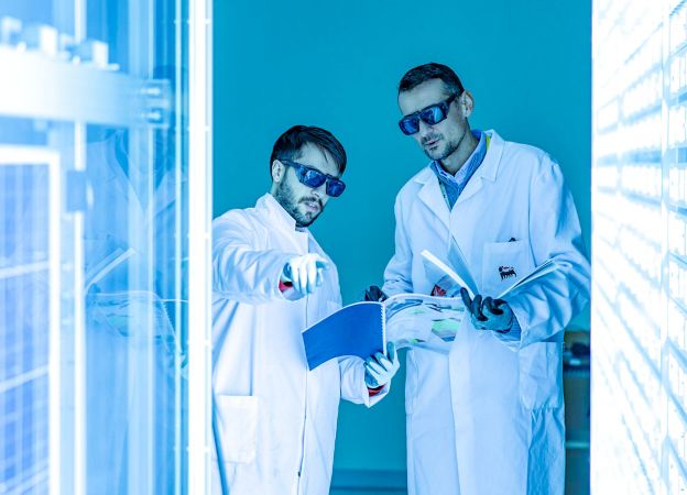Two scientists inside the lab as they analyze the panels around them