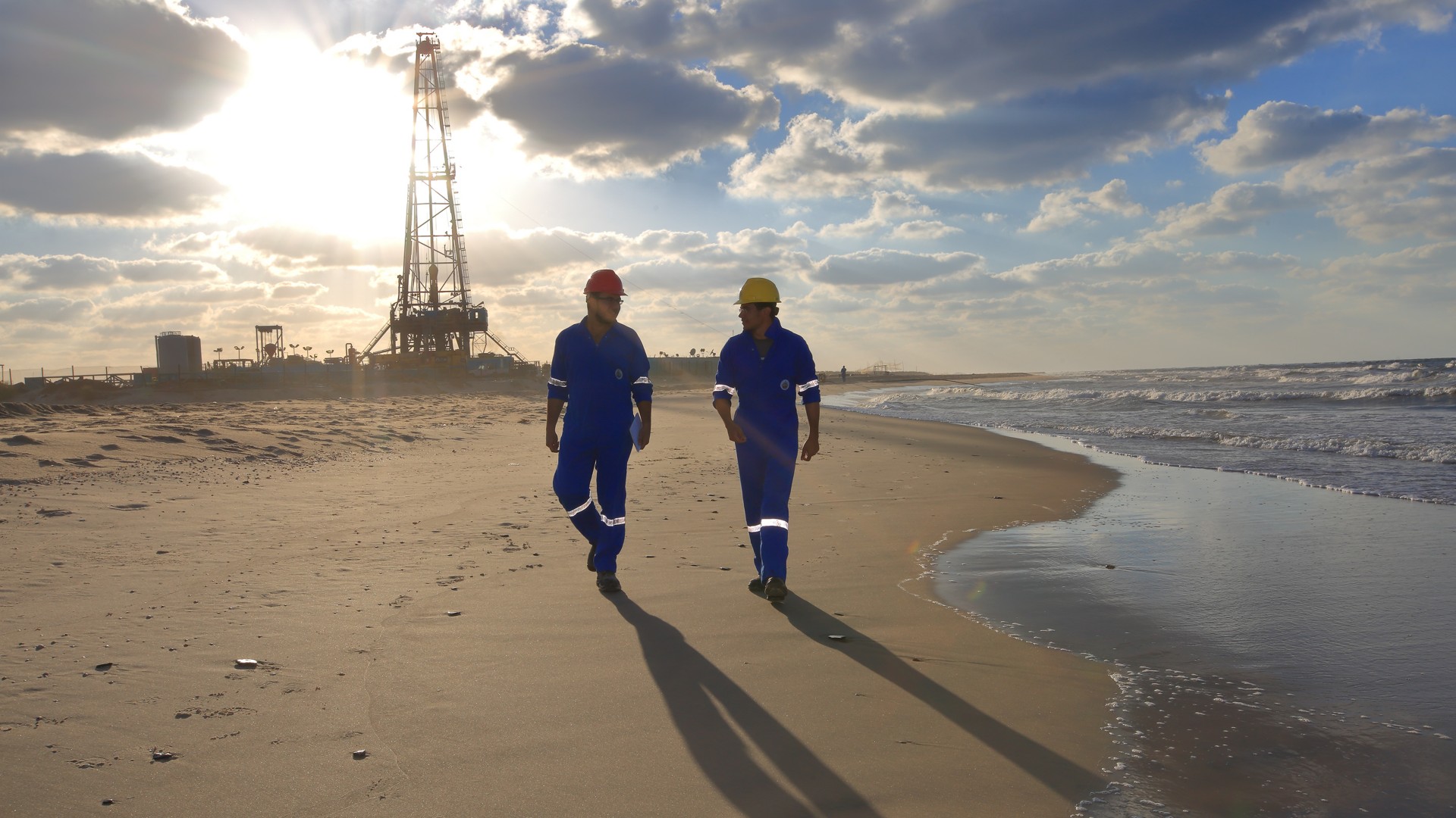 Men on the beach walk near the facility