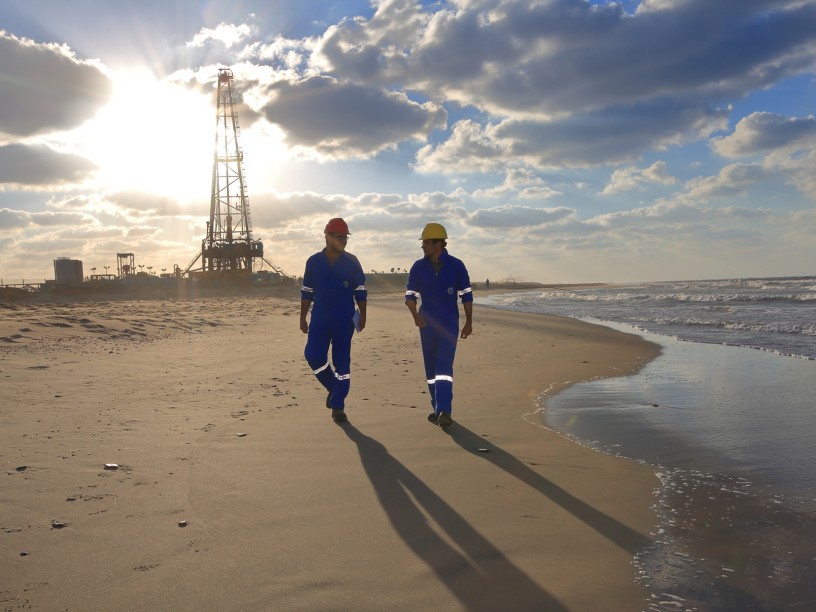 Men on the beach walk near the facility