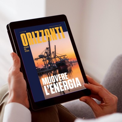 Tablet bianco inclinato su sfondo azzurro mostra la copertina della rivista “Orizzonti” con una nave cargo in porto al tramonto e il titolo “Muovere l’energia”.