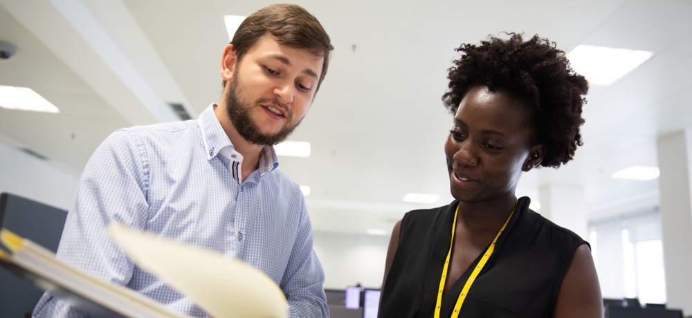 A man and a woman talking in the office