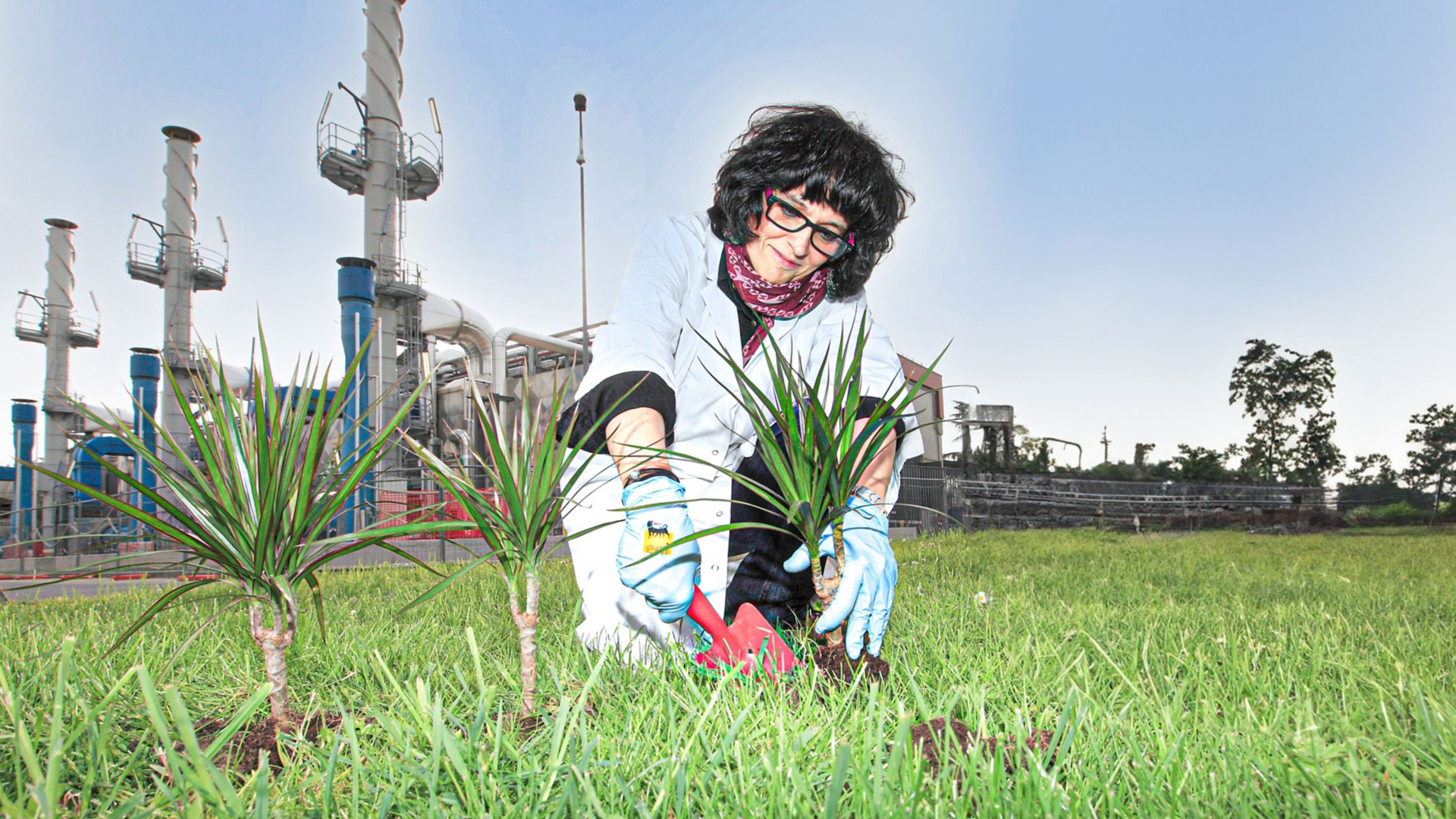 Scientist growing plants near industrial plant