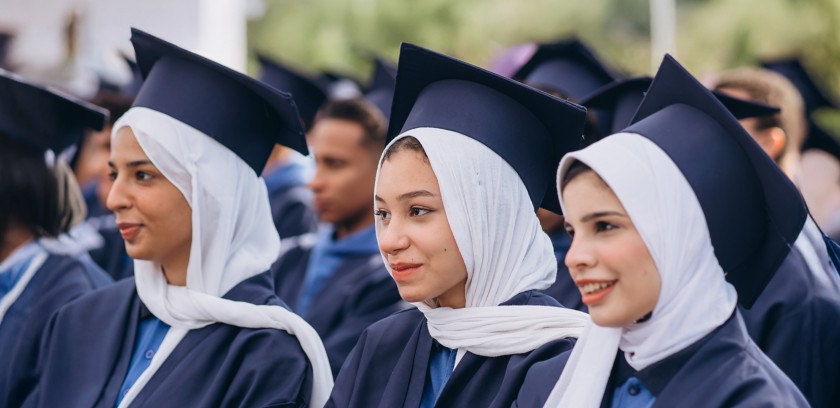 Three female students sitting together during the graduation ceremony