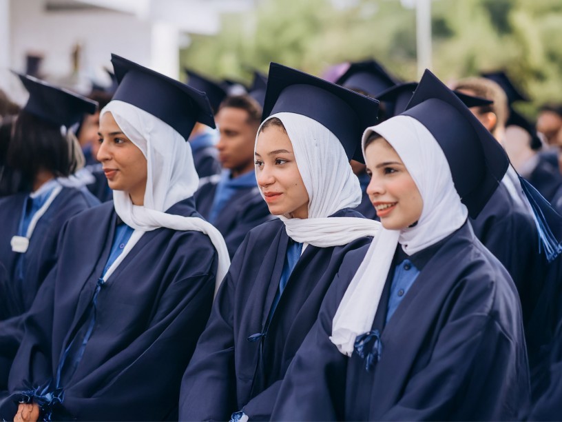 Tre studentesse sedute vicine durante la cerimonia di fine corso