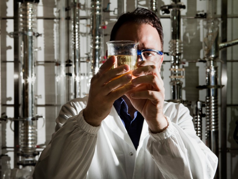 Scientist looking at a test tube in the back light