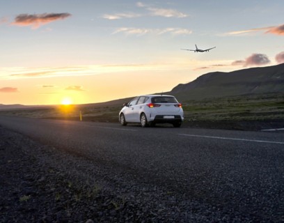 Car on road with airplane in background