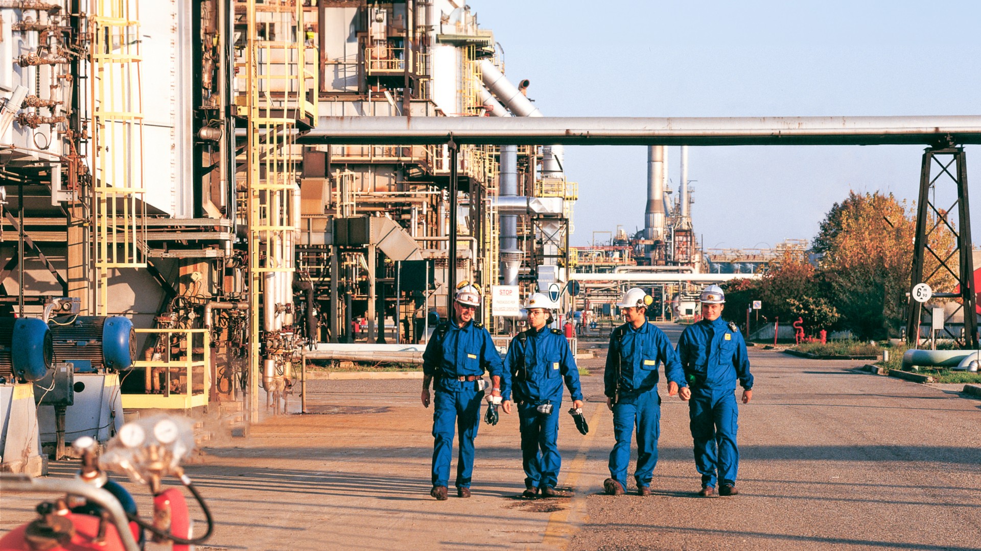 Workers walk inside the Sannazzaro refinery