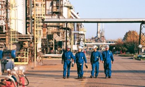 Workers walk inside the Sannazzaro refinery