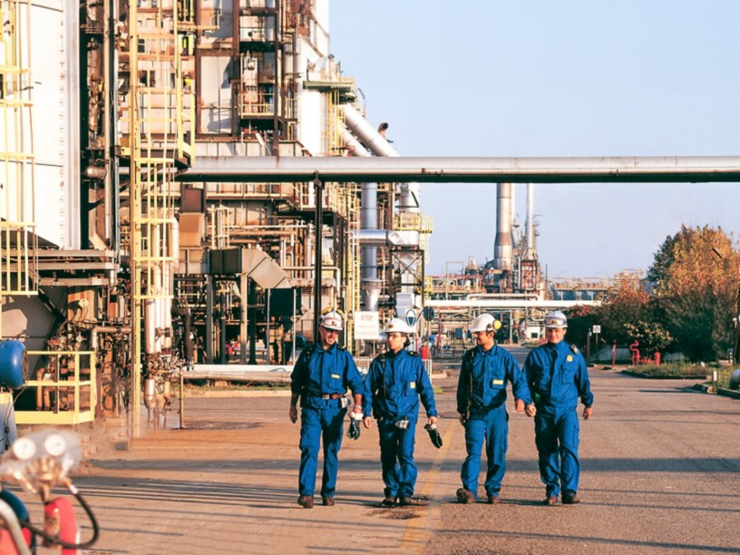 Workers walk inside the Sannazzaro refinery